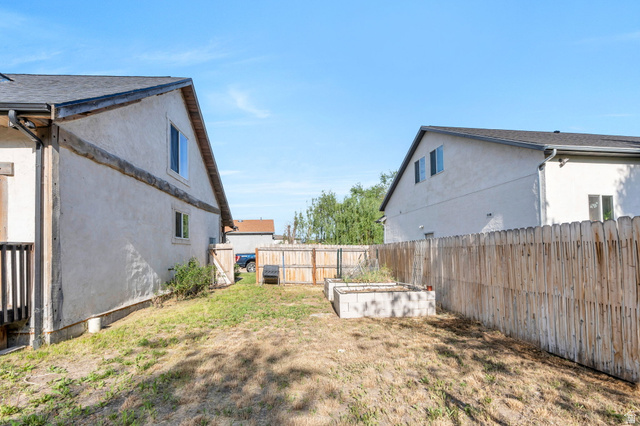 1727 South Sandhill Road Orem, UT 84058 - Photo 27 of 27 Expansive backyard featuring a wood fence, concrete raised garden beds, and a multi-level deck with wood railings
