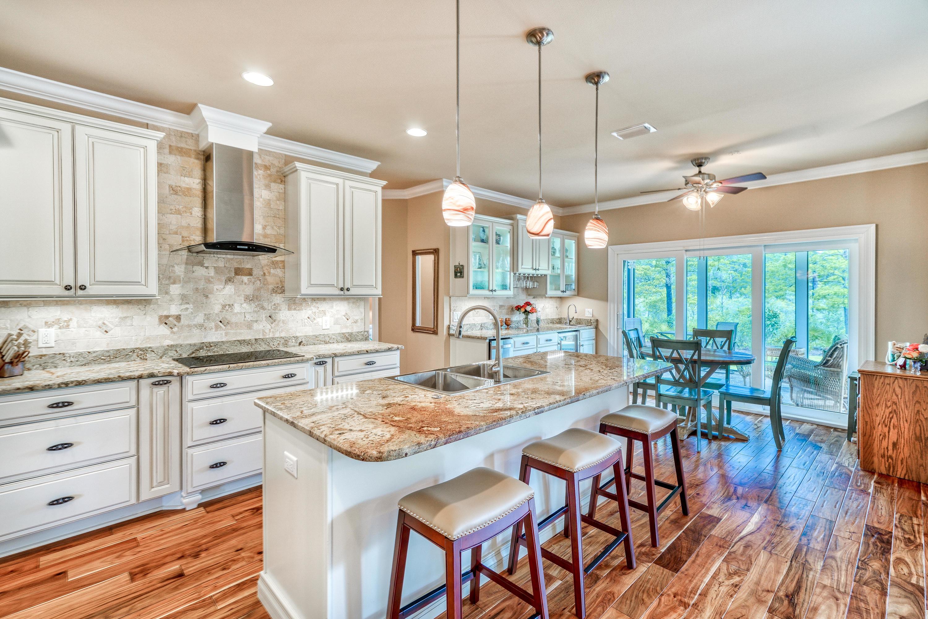 488 Ridge Road Santa Rosa Beach, FL 32459 - Photo 5 of 46 a kitchen with kitchen island granite countertop a table chairs sink and cabinets