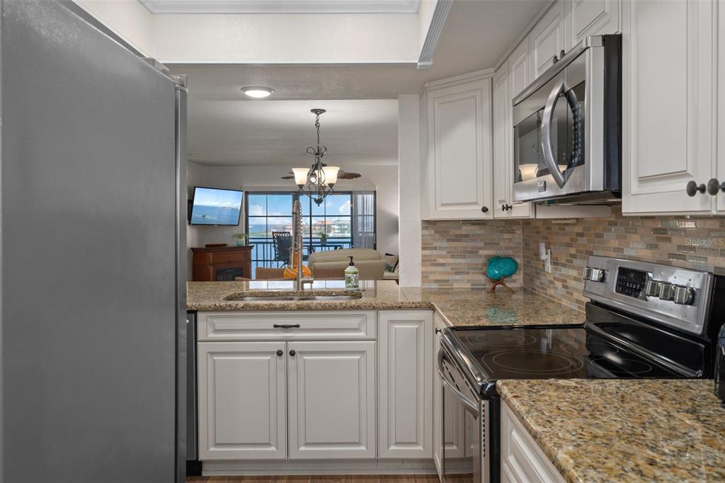 8211 Brent Street, Unit 847 Port Richey, FL 34668 - Photo 13 of 29 a kitchen with stainless steel appliances granite countertop a sink stove and cabinets