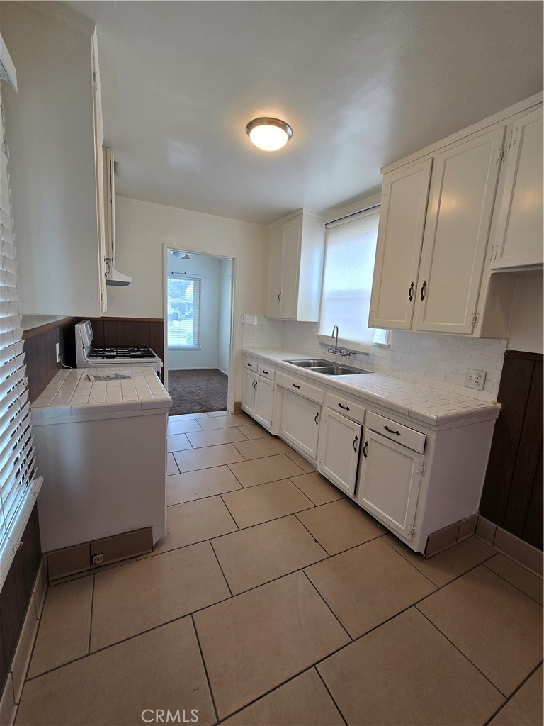 9542 Rex Road Pico Rivera, CA 90660 - Photo 4 of 11 a kitchen with a sink a stove and cabinets