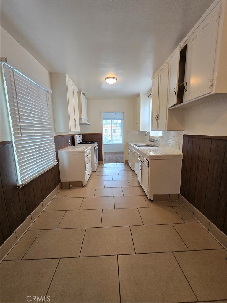 9542 Rex Road Pico Rivera, CA 90660 - Photo 6 of 11 a kitchen with stainless steel appliances a sink a stove a microwave and cabinets