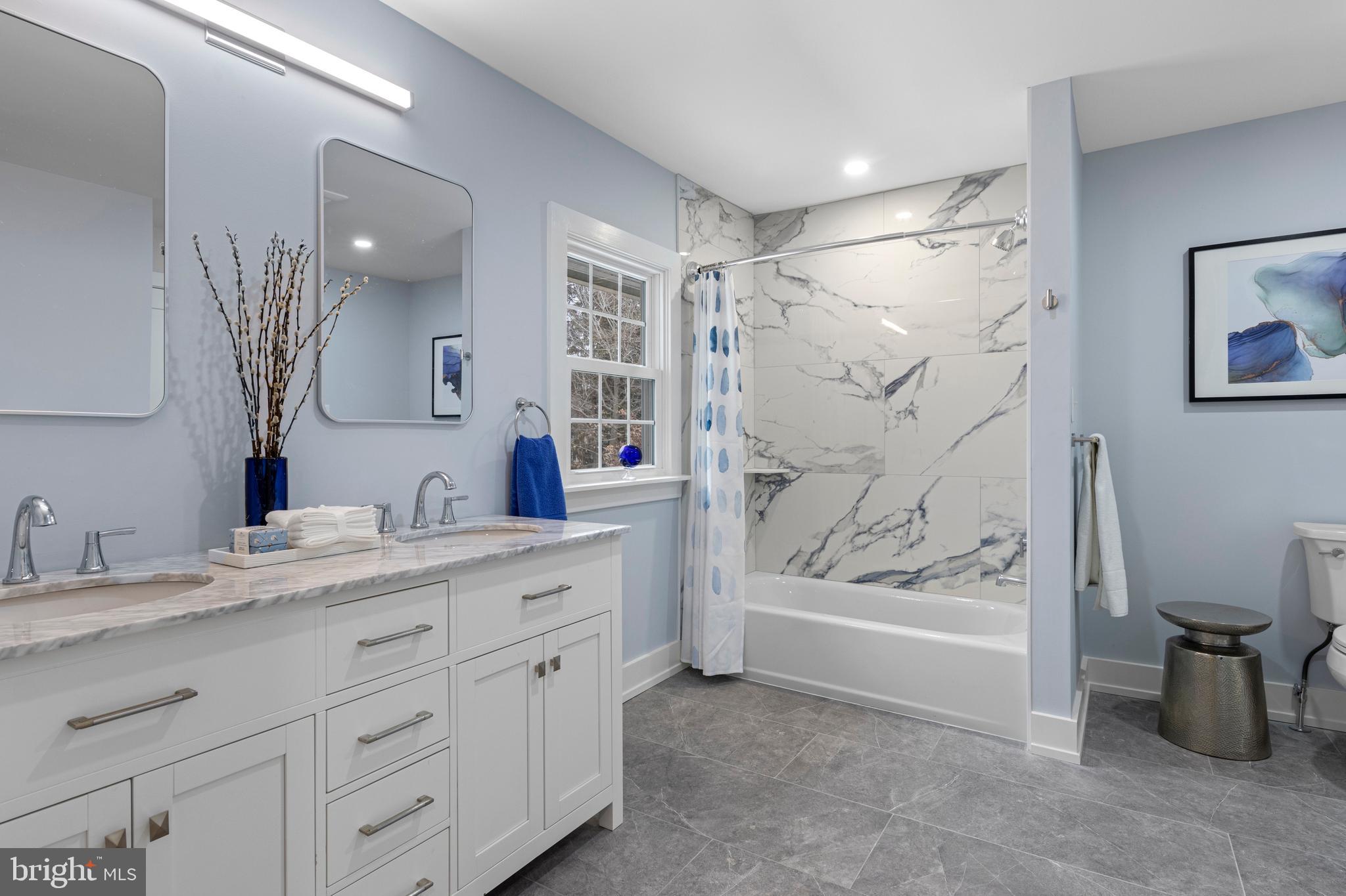 222 Rutgers Avenue Swarthmore, PA 19081 - Photo 21 of 40 a bathroom with a granite countertop sink a mirror a vanity and a bathtub