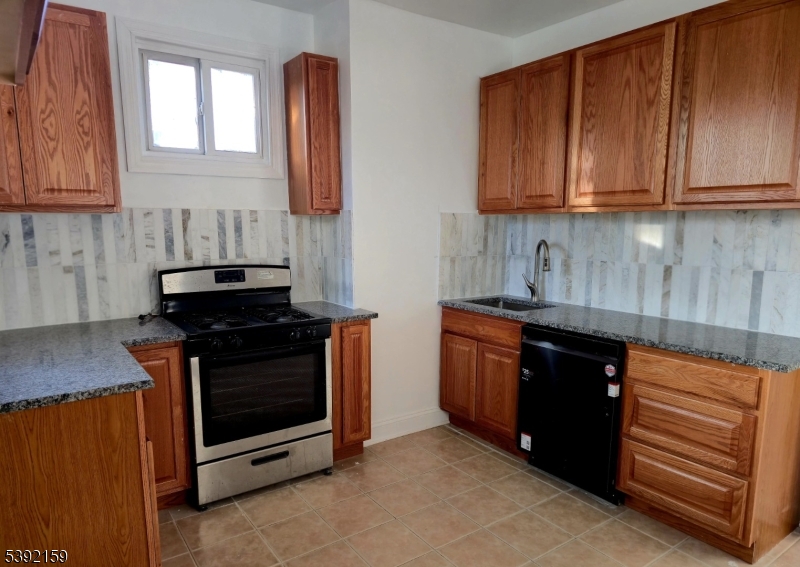 204 Chancellor Avenue, Unit 2 Newark, NJ 07112 - Photo 1 of 1 a kitchen with stainless steel appliances granite countertop a stove and a microwave