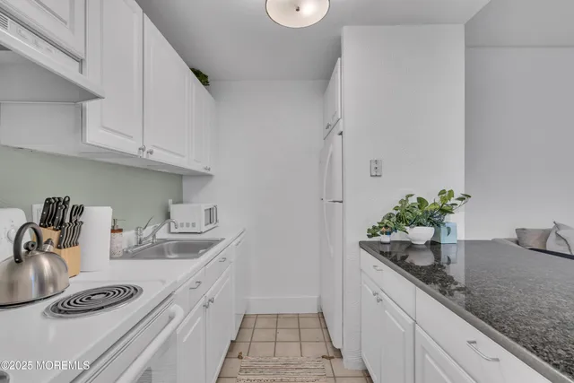 a kitchen with stainless steel appliances granite countertop a sink a stove and cabinets