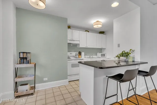 a kitchen with granite countertop white cabinets and appliances