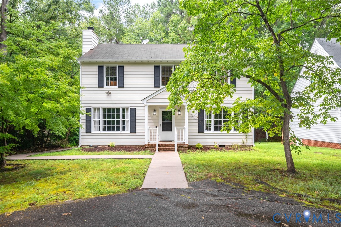 Colonial house with a chimney and a front yard