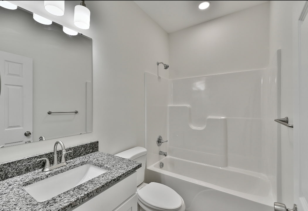 808 Delia Street Anderson, SC 29624 - Photo 14 of 17 This modern bathroom features a clean design with granite countertops and a shower-tub combination.