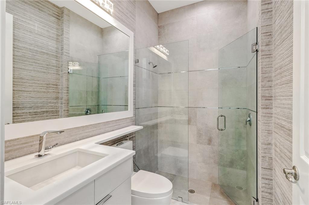 4410 Caldera Circle Naples, FL 34119 - Photo 18 of 35 a bathroom with a sink toilet vanity and shower