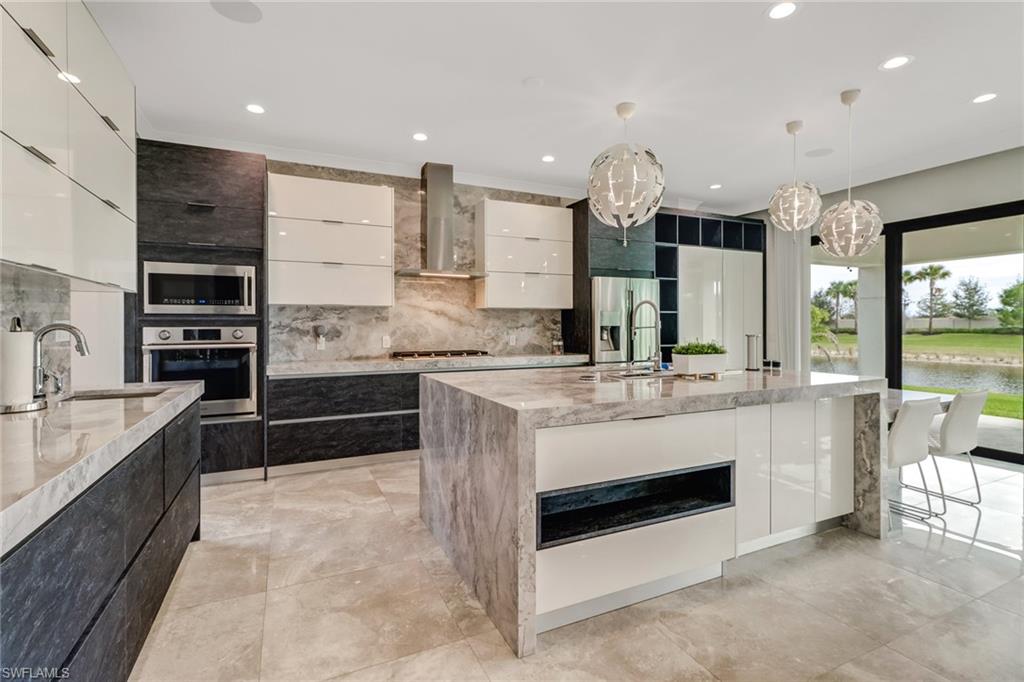 4410 Caldera Circle Naples, FL 34119 - Photo 6 of 35 a kitchen with stainless steel appliances granite countertop a stove and a sink