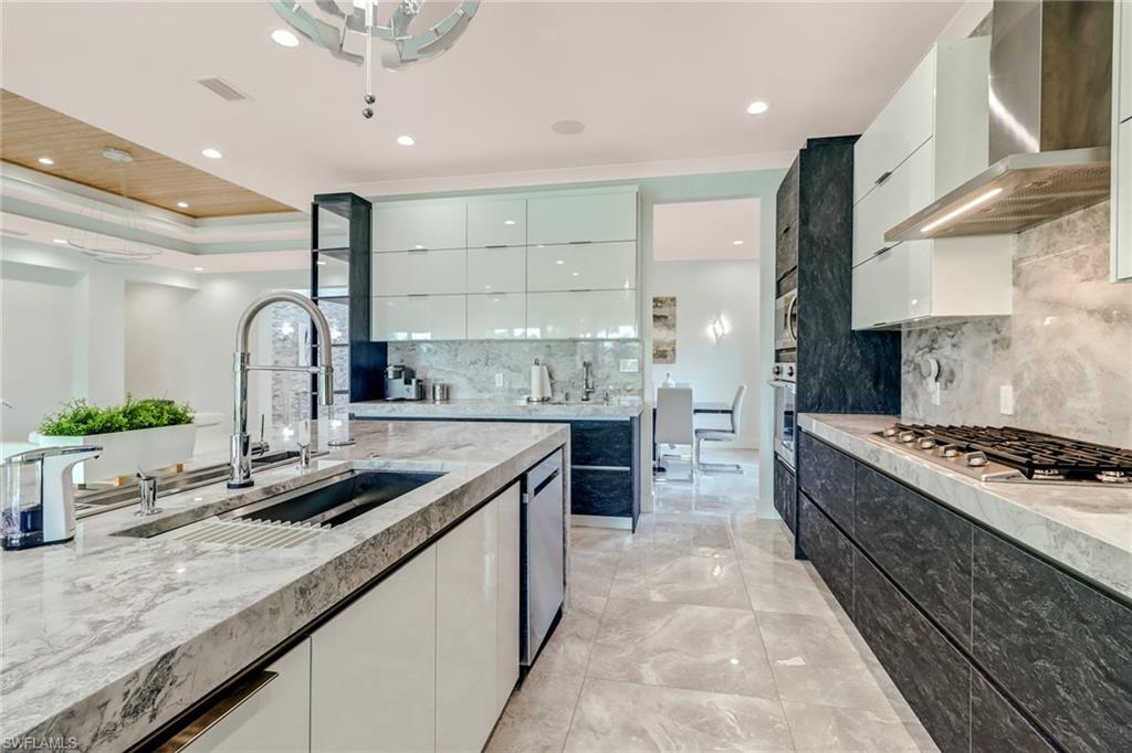 4410 Caldera Circle Naples, FL 34119 - Photo 7 of 35 a kitchen with stainless steel appliances granite countertop a sink stove and cabinets