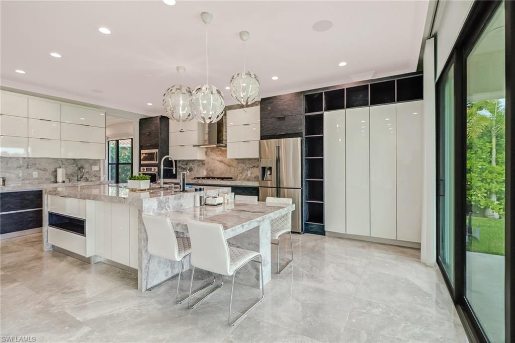 4410 Caldera Circle Naples, FL 34119 - Photo 8 of 35 a kitchen with kitchen island cabinets and refrigerator