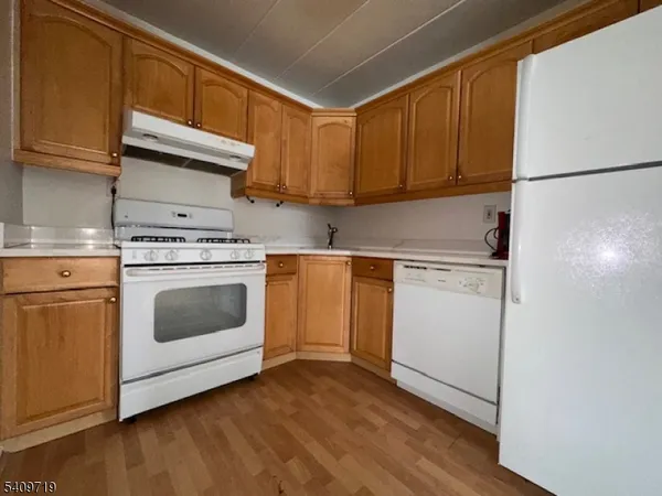 a kitchen with cabinets appliances and wooden floor