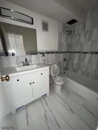 a spacious bathroom with a double vanity sink toilet and a mirror