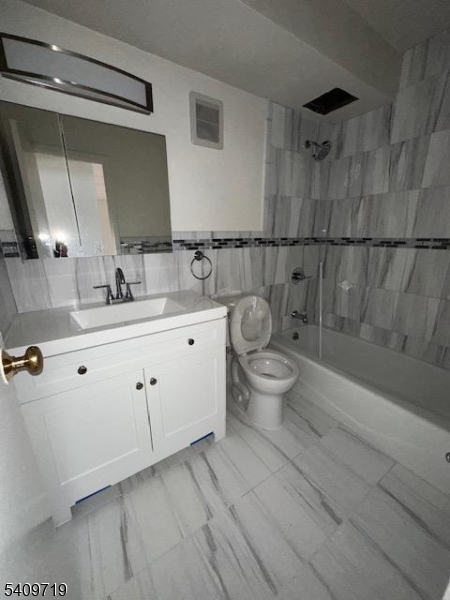 77 Prospect Avenue, Unit D Hackensack, NJ 07601 - Photo 4 of 14 a spacious bathroom with a double vanity sink toilet and a mirror