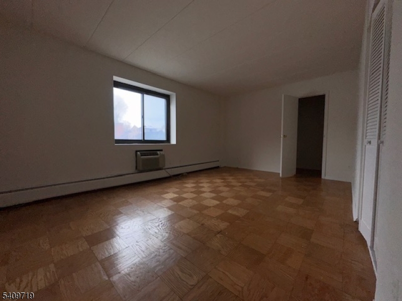 77 Prospect Avenue, Unit D Hackensack, NJ 07601 - Photo 7 of 14 an empty room with wooden floor and windows
