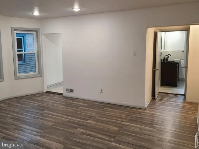 an empty room with wooden floor and a window