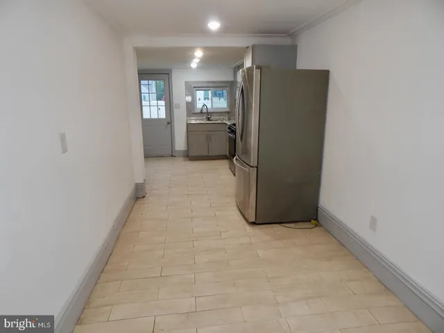 a view of a refrigerator in kitchen and utility room