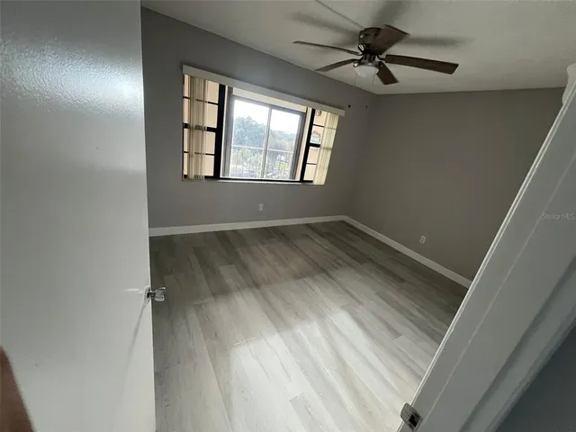 an empty room with windows and fan