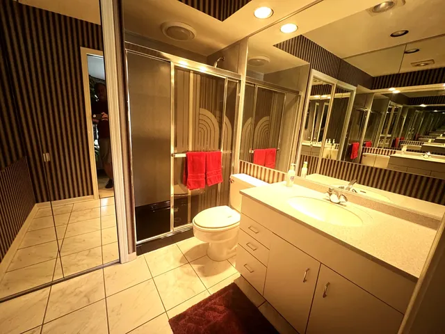 a bathroom with a sink toilet vanity and shower