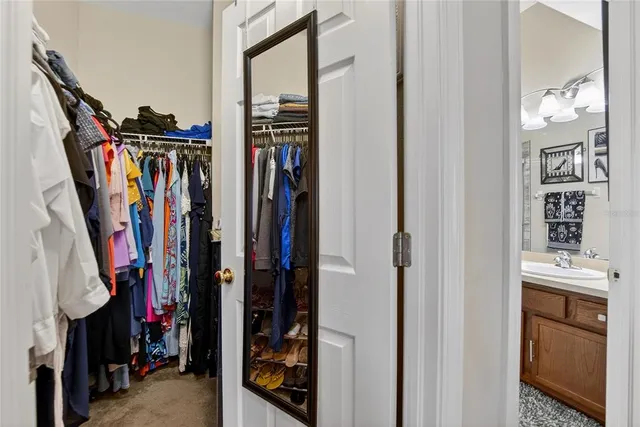 a view of walk in closet with clothes and shoes