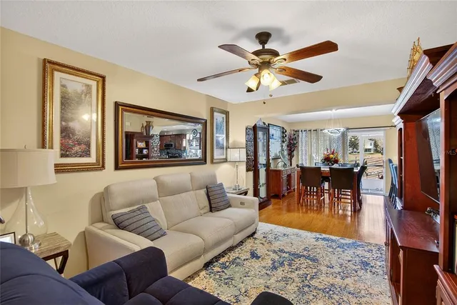 a living room with furniture kitchen view and a chandelier