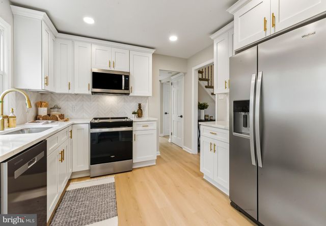 a kitchen with white cabinets and stainless steel appliances