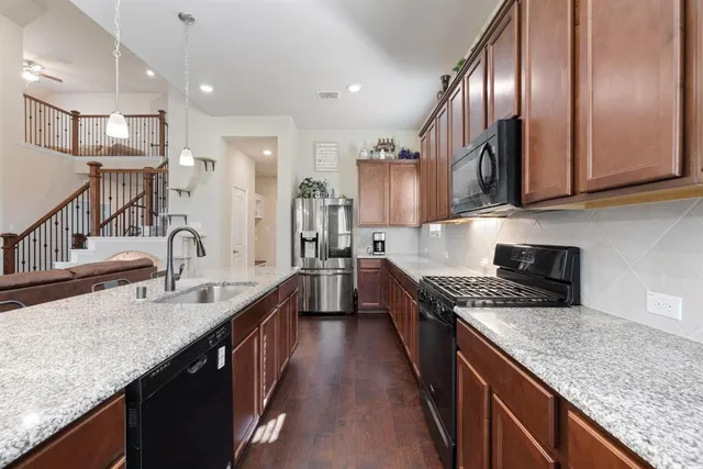 a kitchen with stainless steel appliances granite countertop a sink stove and refrigerator