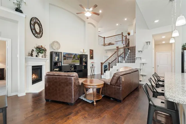 a living room with furniture a fireplace and a ceiling fan
