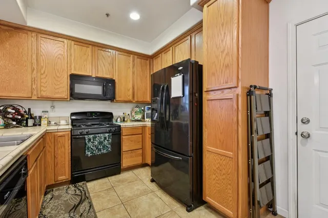 a kitchen with stainless steel appliances granite countertop a refrigerator stove and sink