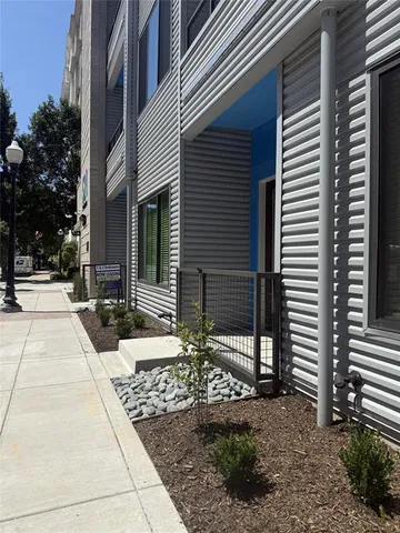 an empty room with wooden floor cabinet and windows