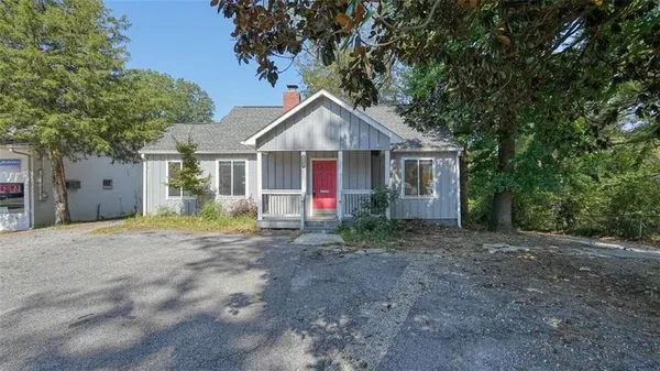 a view of a house with a yard and large tree