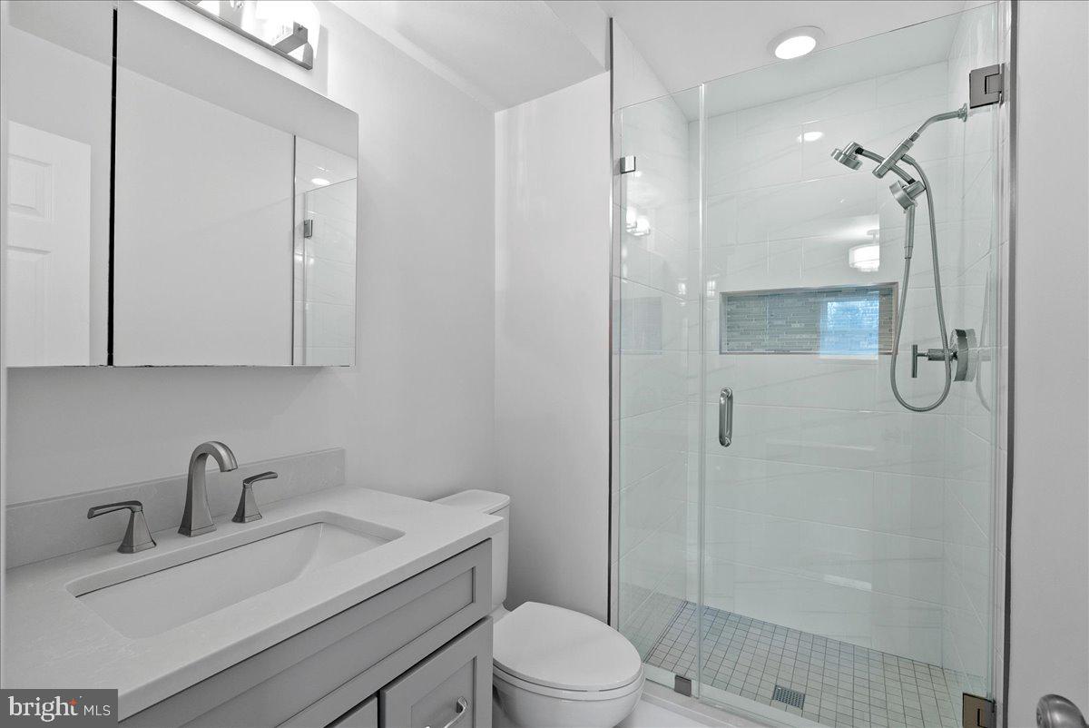 7845 Brompton Street Springfield, VA 22152 - Photo 16 of 32 a bathroom with a granite countertop sink toilet and shower