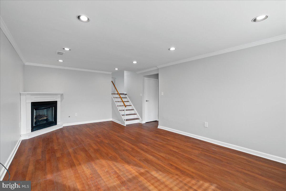 7845 Brompton Street Springfield, VA 22152 - Photo 24 of 32 a view of an empty room with wooden floor and a fireplace
