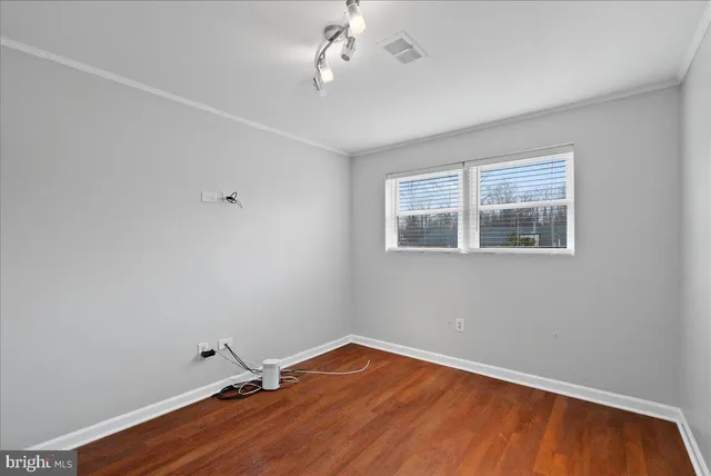 a view of a room with wooden floor and fan