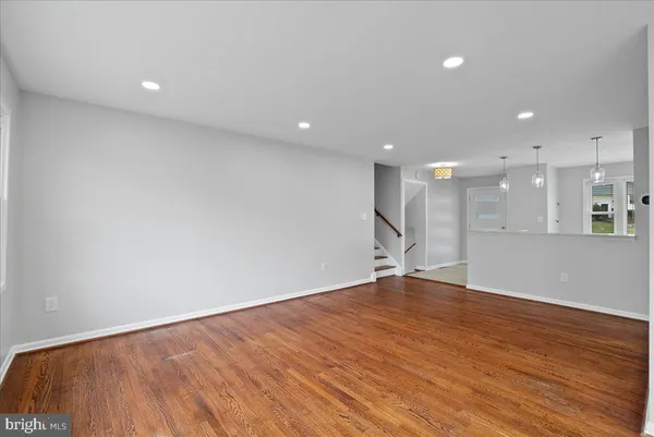 a view of an empty room with wooden floor