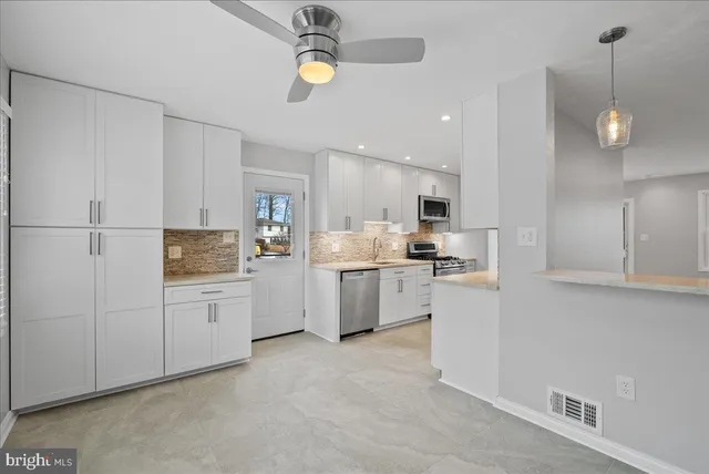 a kitchen with white cabinets and white appliances