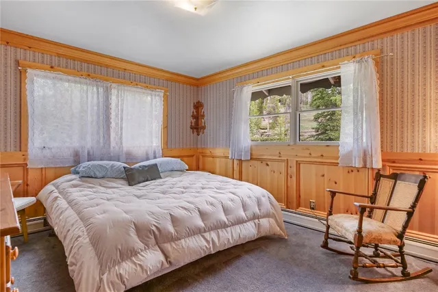 a bedroom with a bed chair and next to a window