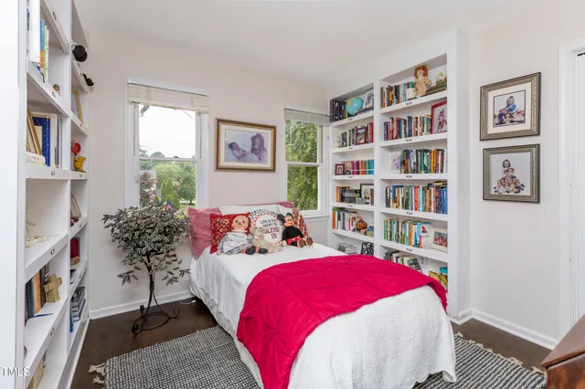a bed room with a bed a book shelf and a window