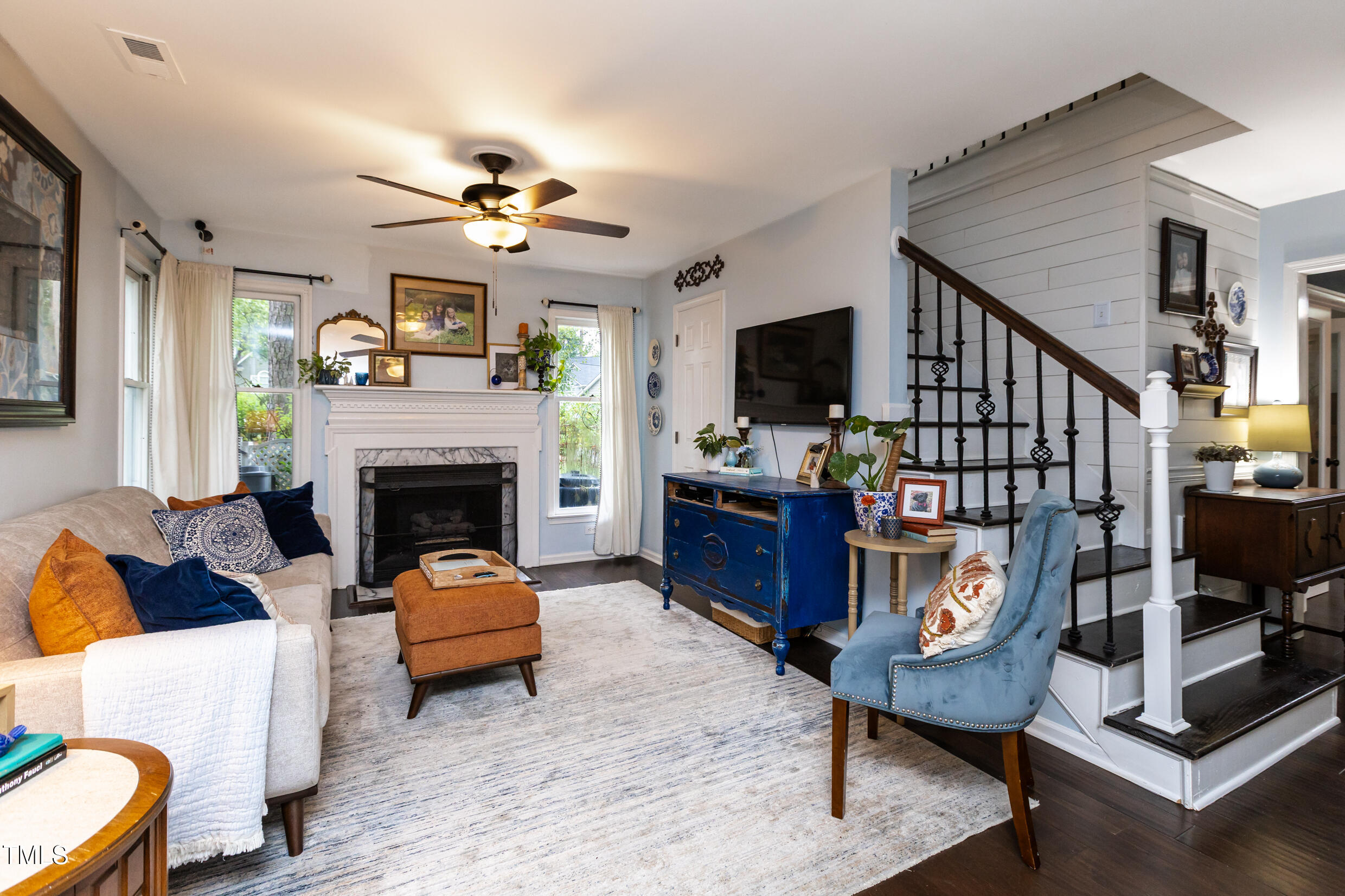 12116 Queensbridge Court Raleigh, NC 27613 - Photo 6 of 16 a living room with furniture a flat screen tv and a fireplace