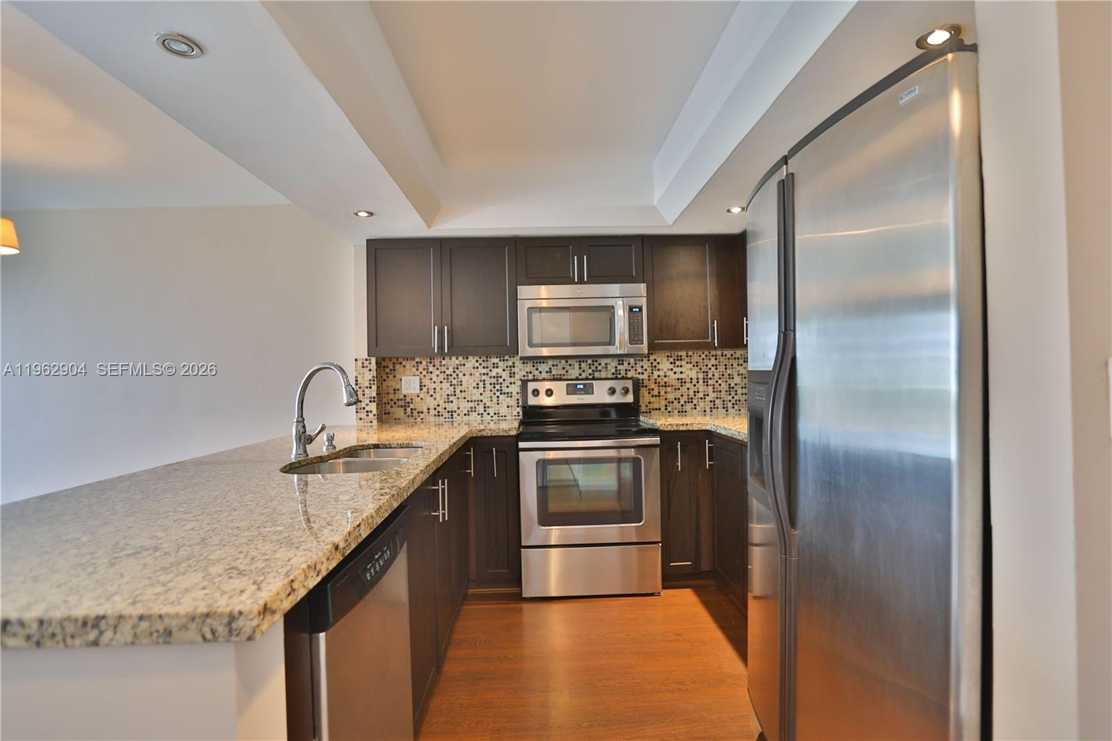 600 Northeast 36th Street, Unit 507 Miami, FL 33137 - Photo 7 of 23 a kitchen with kitchen island granite countertop stainless steel appliances and a sink