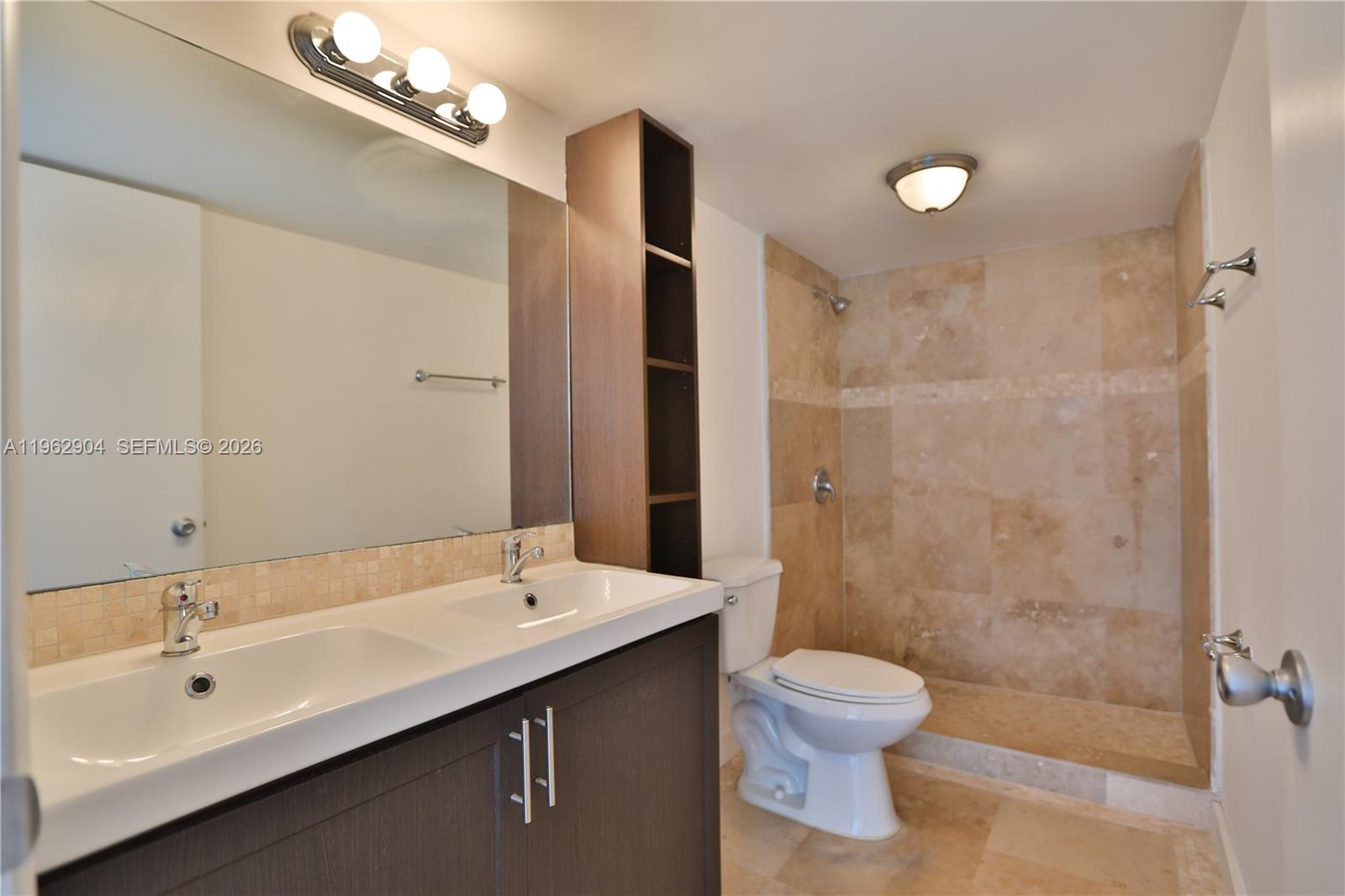 600 Northeast 36th Street, Unit 507 Miami, FL 33137 - Photo 10 of 23 a bathroom with a double vanity sink toilet a shower and a mirror