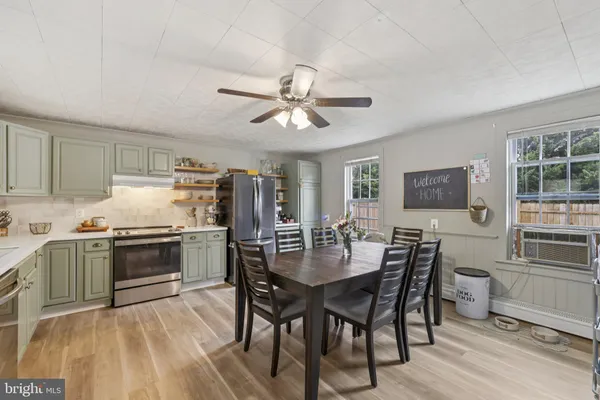 a kitchen with a table chairs stove and refrigerator