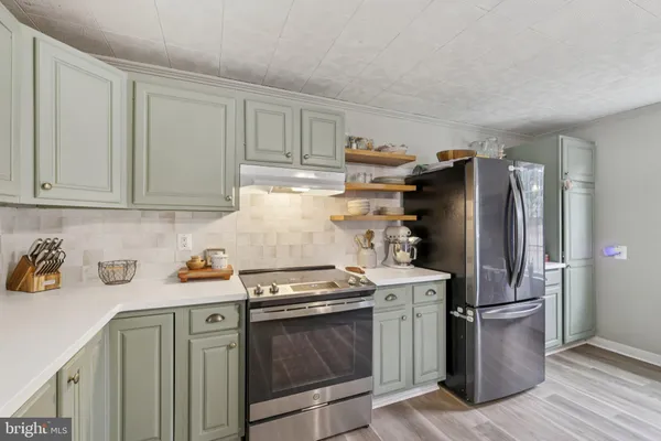 a kitchen with a stove top oven and refrigerator