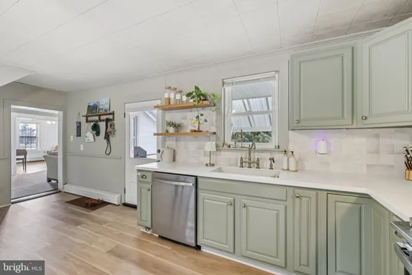 a kitchen with a sink cabinets and wooden floor