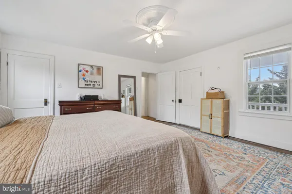 a bedroom with a large bed a chandelier and dresser