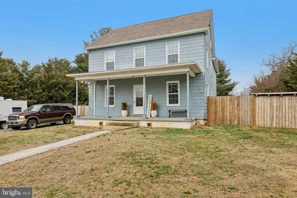 a view of a house with a patio and a yard