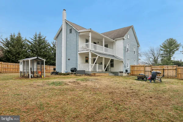 a view of a house with backyard and trees