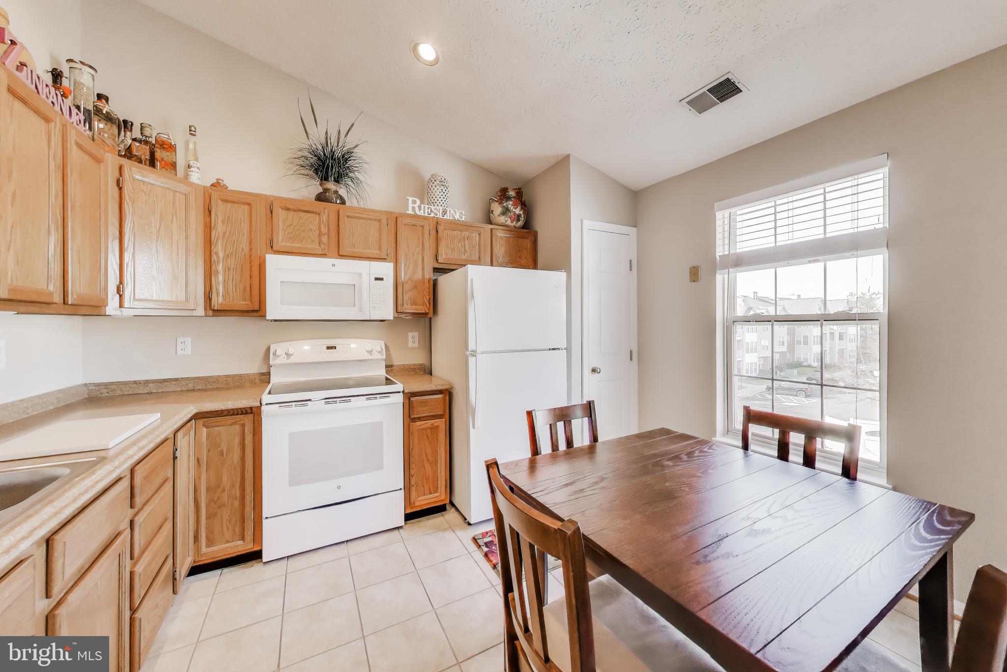 687 Winding Stream Way, Unit 304 Odenton, MD 21113 - Photo 3 of 33 a kitchen with a table chairs refrigerator and cabinets