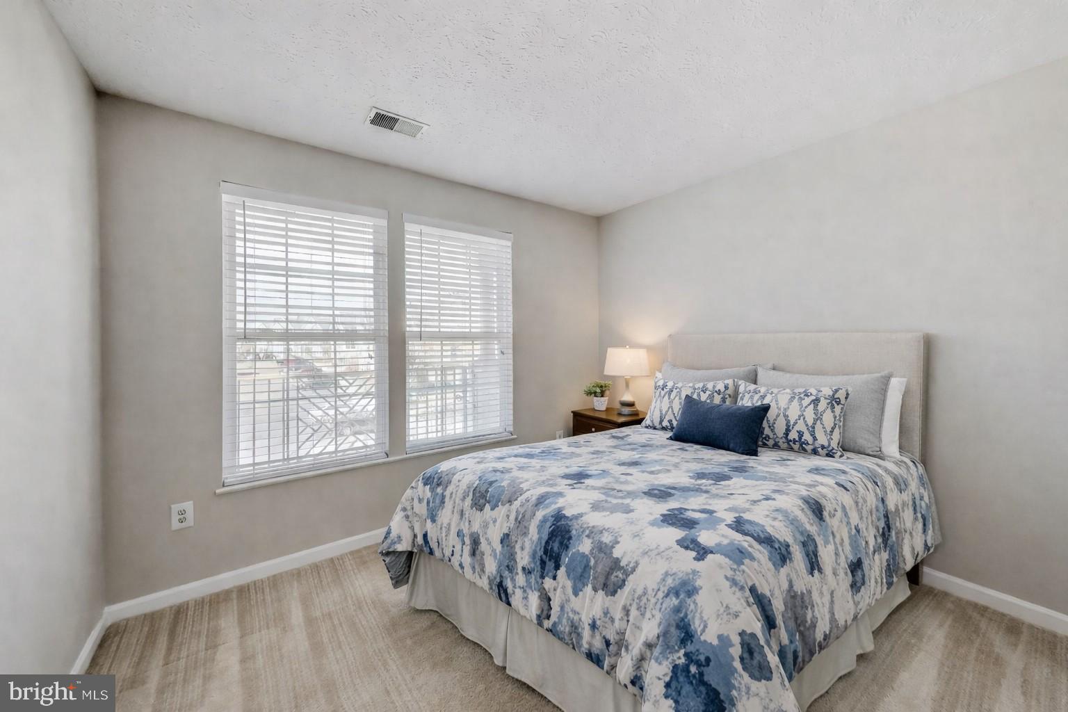 687 Winding Stream Way, Unit 304 Odenton, MD 21113 - Photo 5 of 33 a large bed sitting in a bedroom next to a window