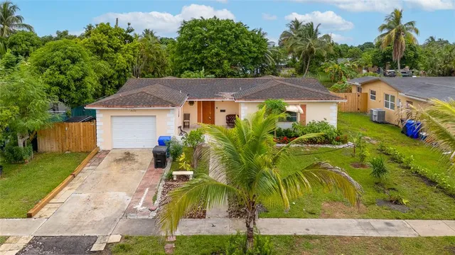an aerial view of a house with a garden and trees